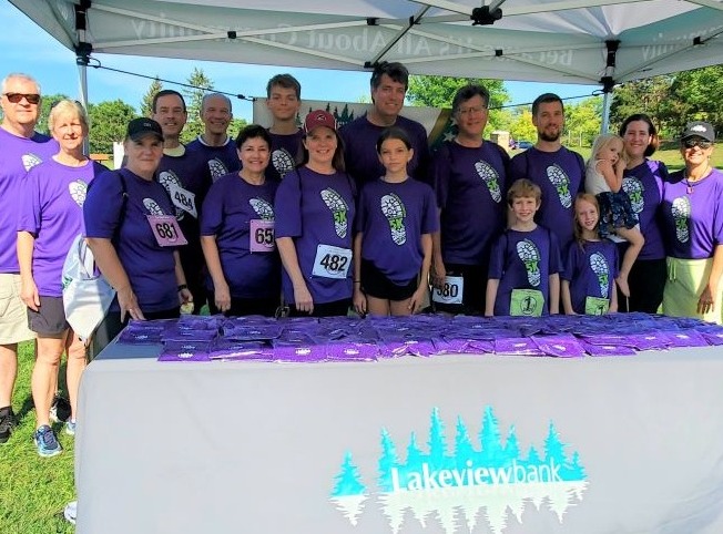 Group photo under canopy at outdoor 5k event